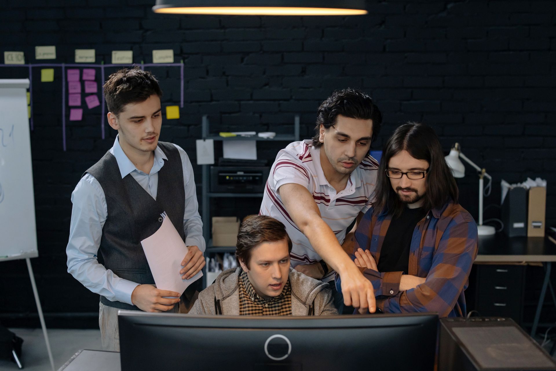 A team collaborating around a monitor in a modern office