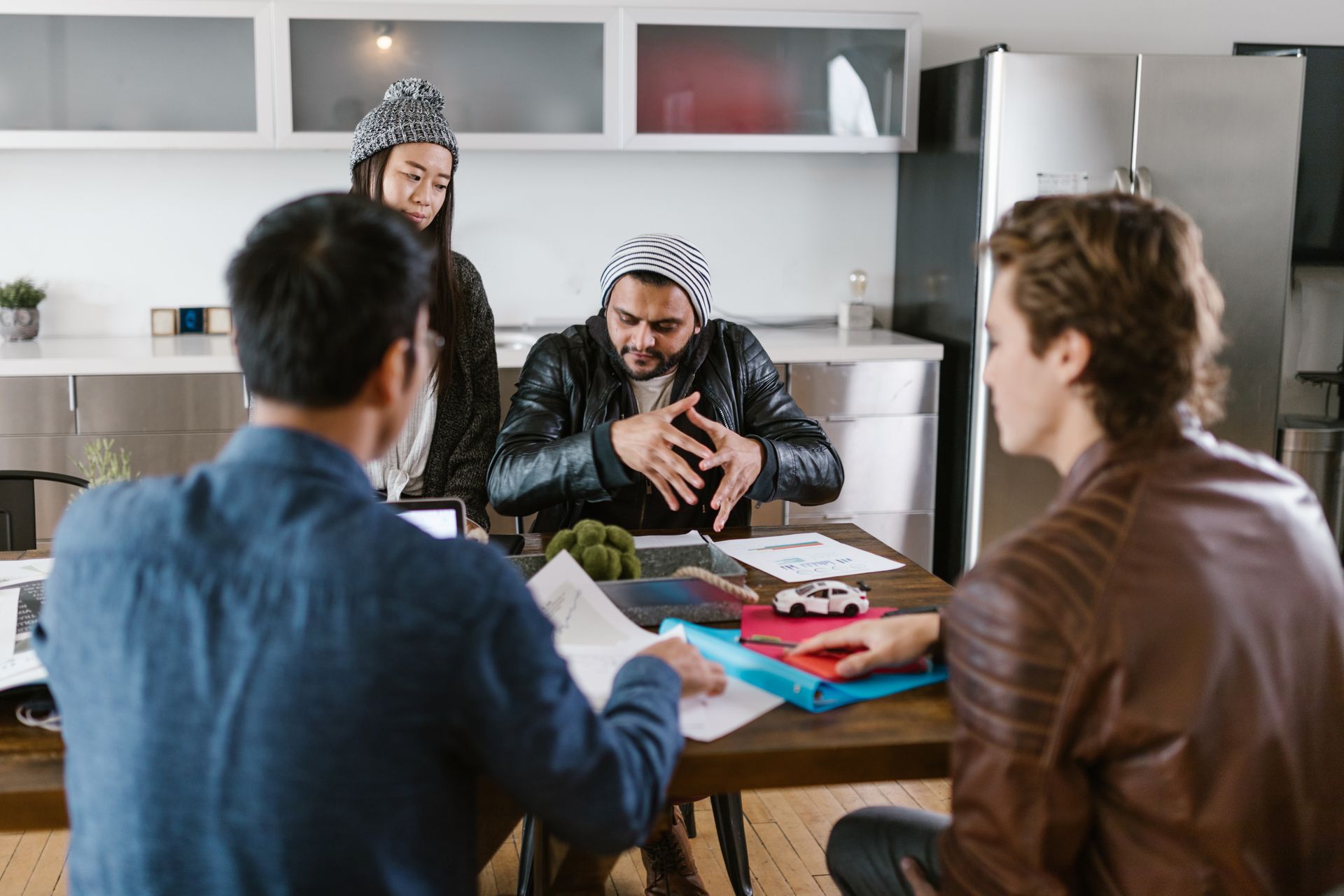 A diverse team in an animated discussion around a work table