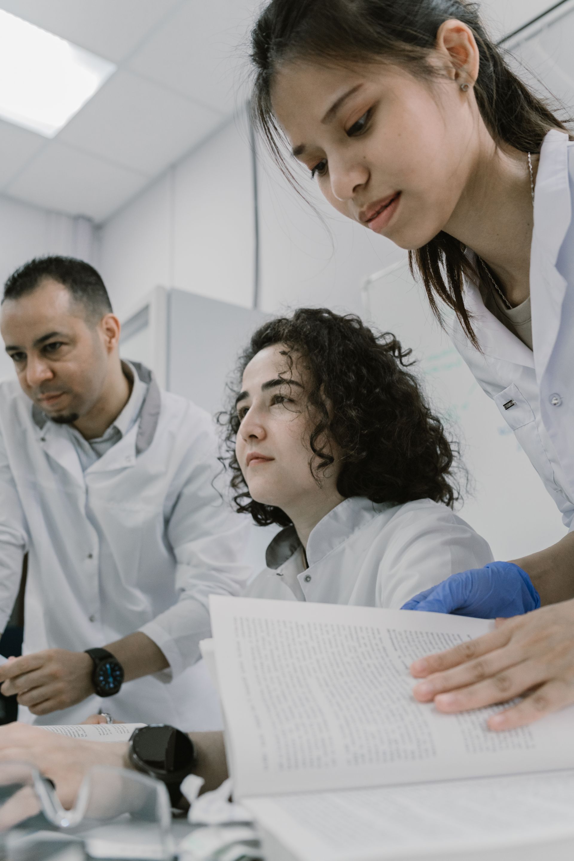 Three scientists collaborating in a modern research laboratory