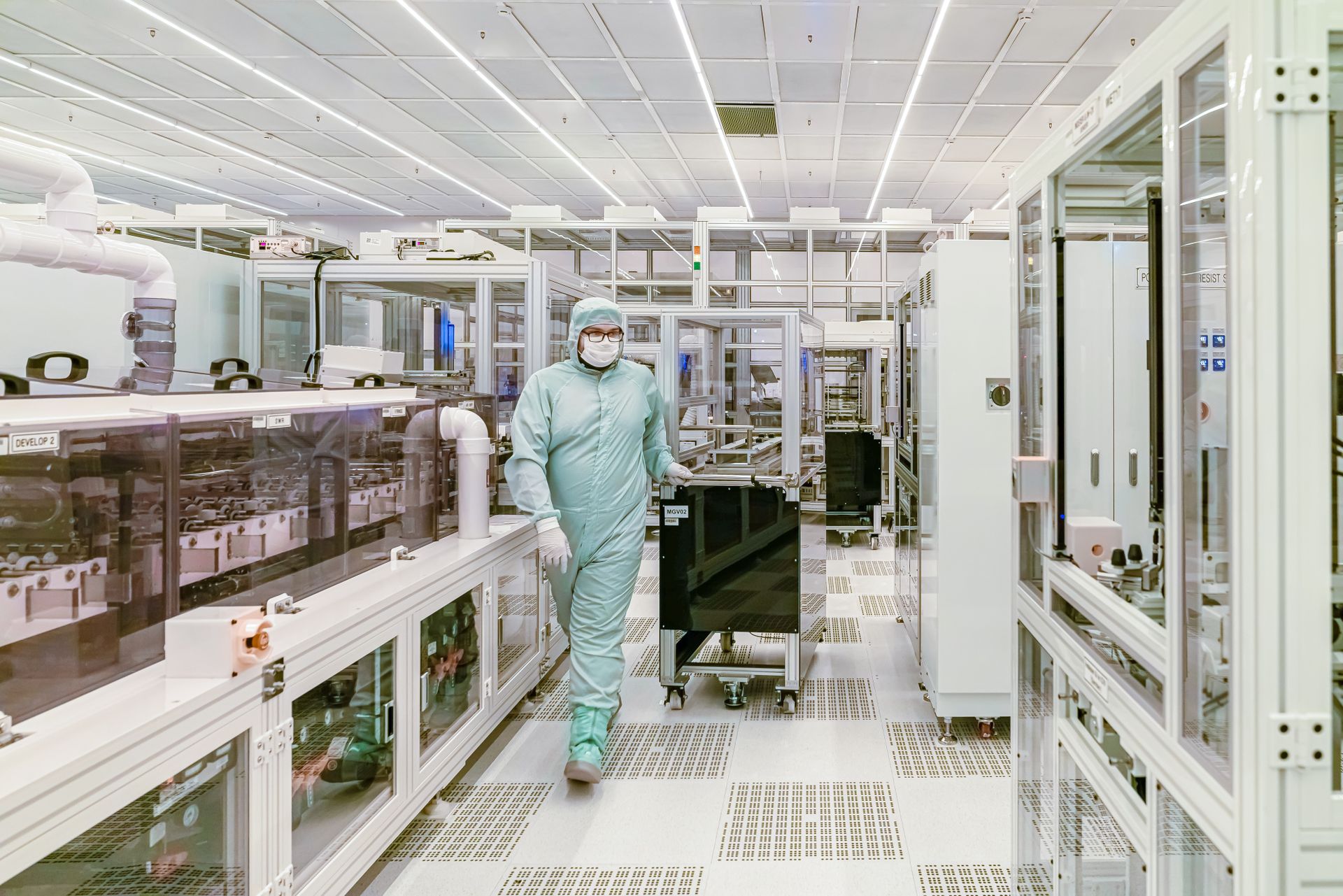 A scientist in protective gear walking through a cleanroom facility