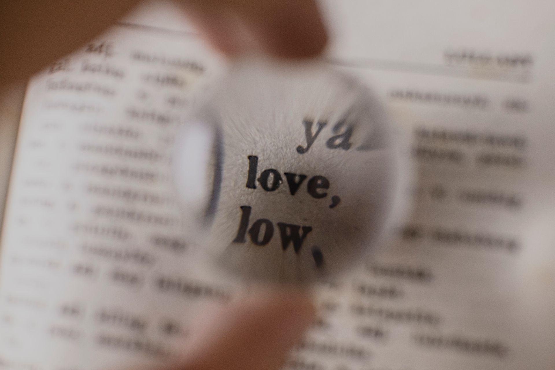 A magnifying glass focusing on a word in an open dictionary