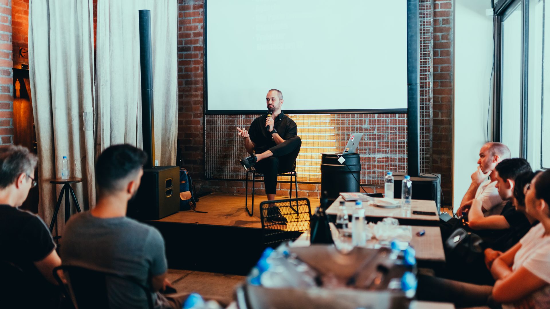 A speaker with a microphone addressing an attentive seminar audience