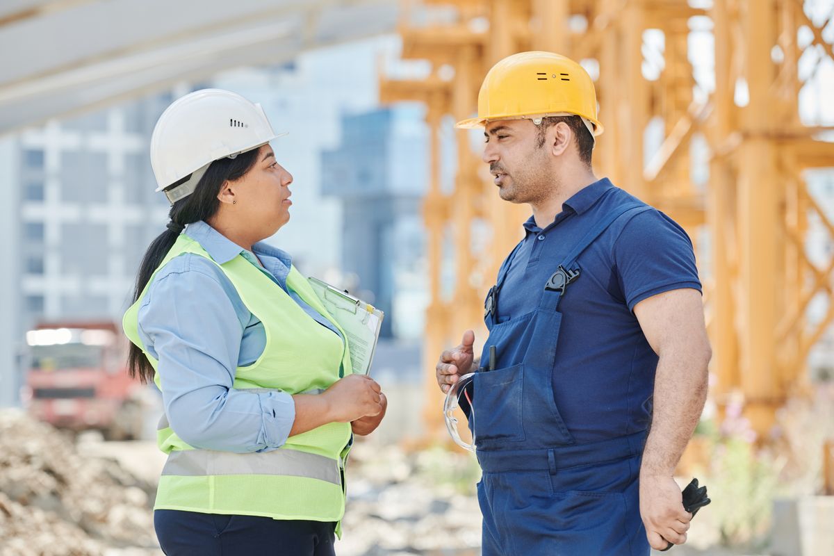A site manager briefing her crew at the project board