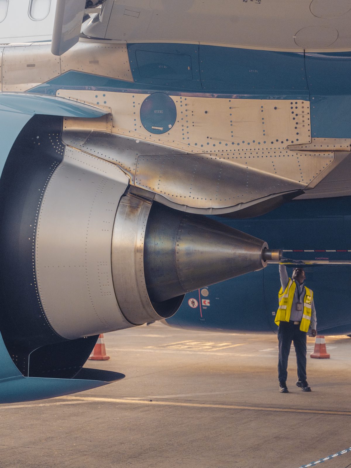 A safety officer inspecting an aircraft engine on the tarmac