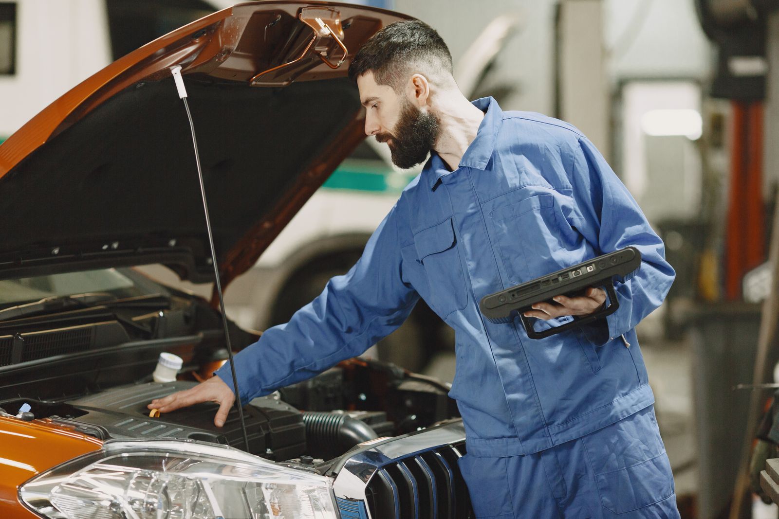A technician diagnosing an electric vehicle with a tablet