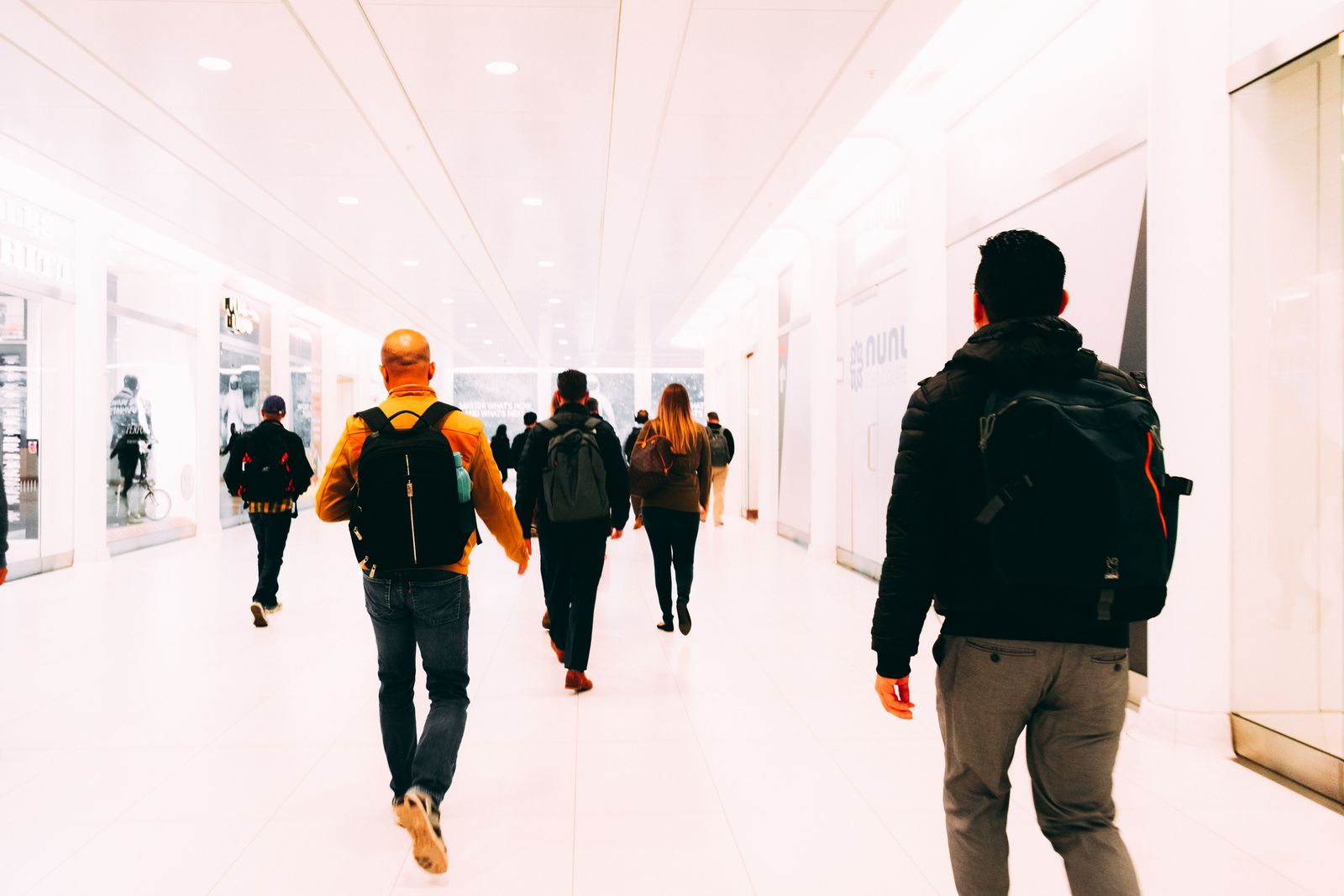 Travelers with backpacks walking through a bright terminal