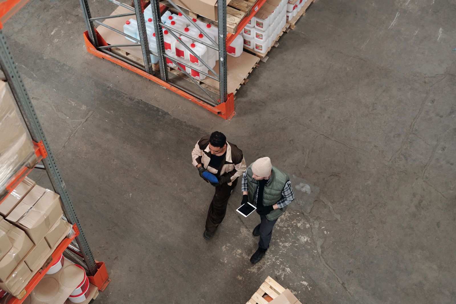 Two warehouse colleagues coordinating with a tablet