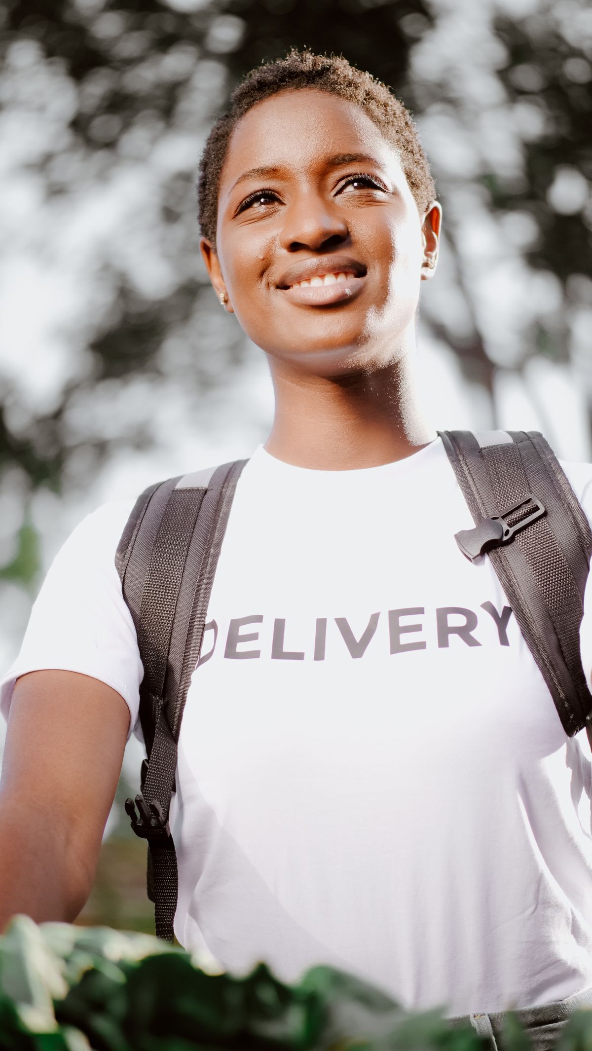 A delivery worker smiling in uniform on a city street
